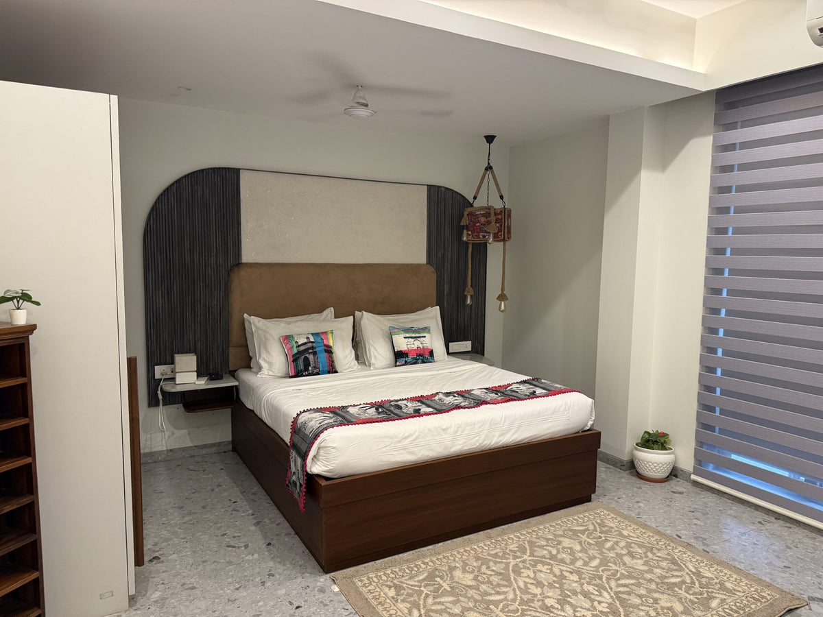 Calm, neatly made bedroom with soft lighting and a cozy headboard, representing a gentle evening wind-down space