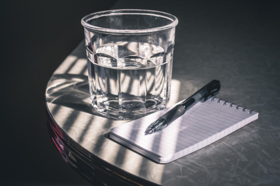 Blank notepad, pen, and glass of water for preparing a care team conversation