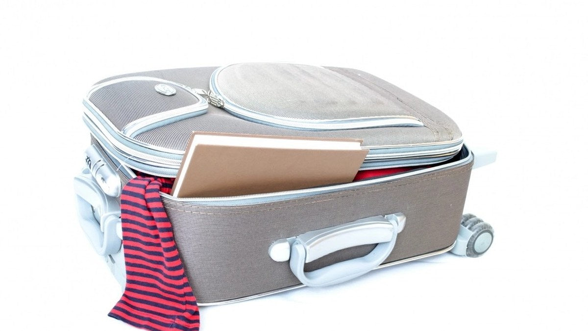 Partially packed suitcase with clothing for a private backup plan