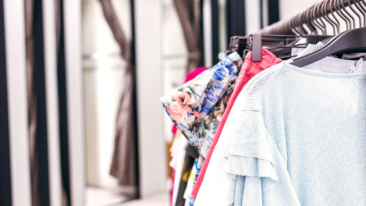 Colorful shirts and light layers hanging on a clothing rack