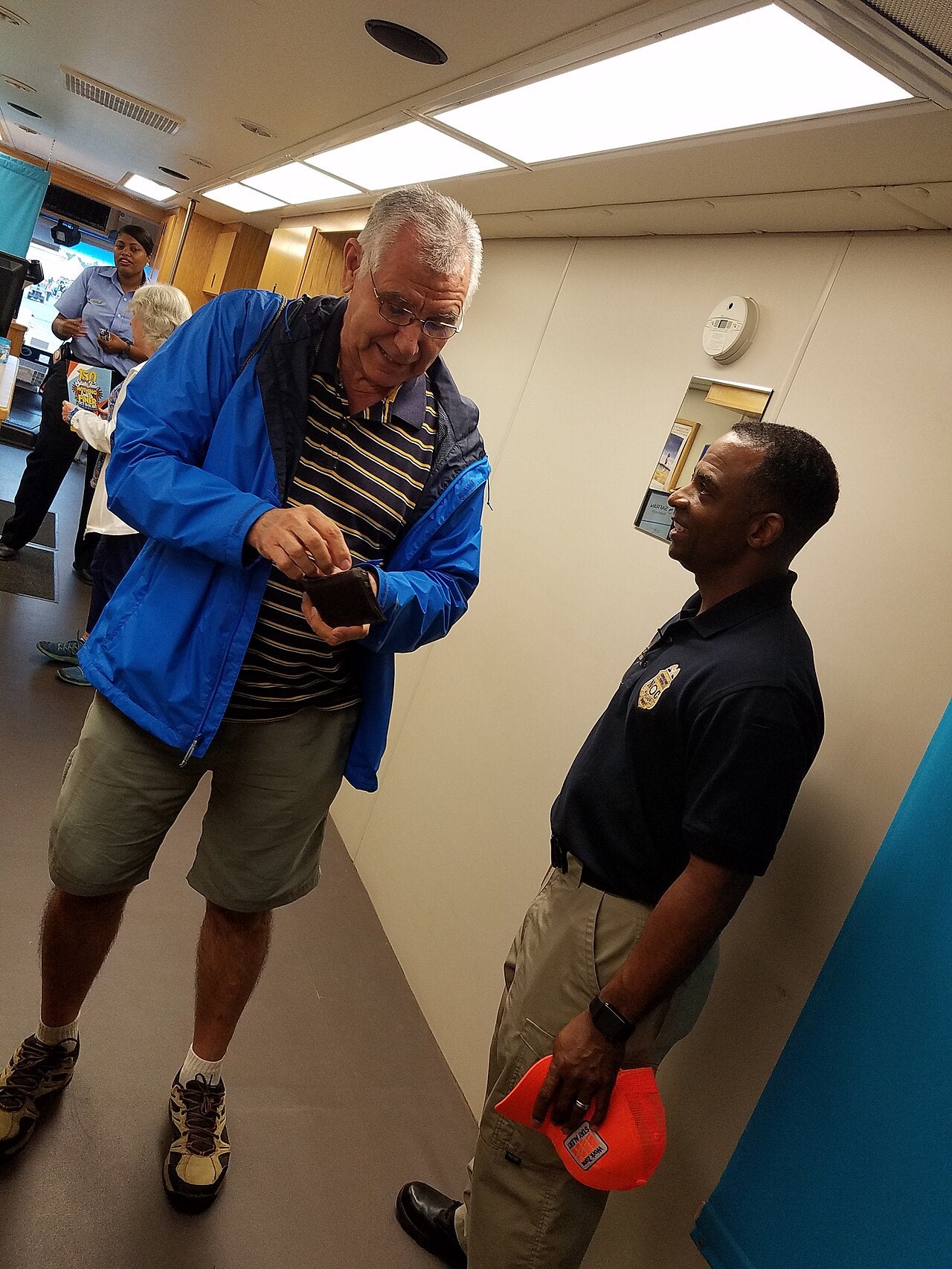 Two adults speaking inside a mobile driver license office during a public information event