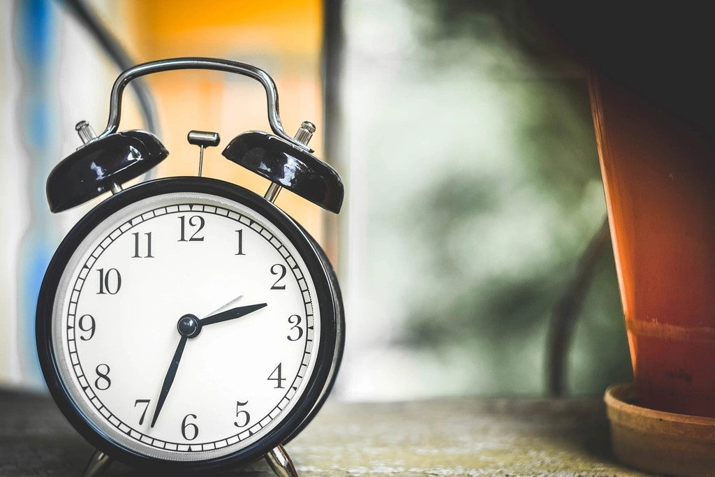 Alarm clock by a softly lit window for planning an early appointment