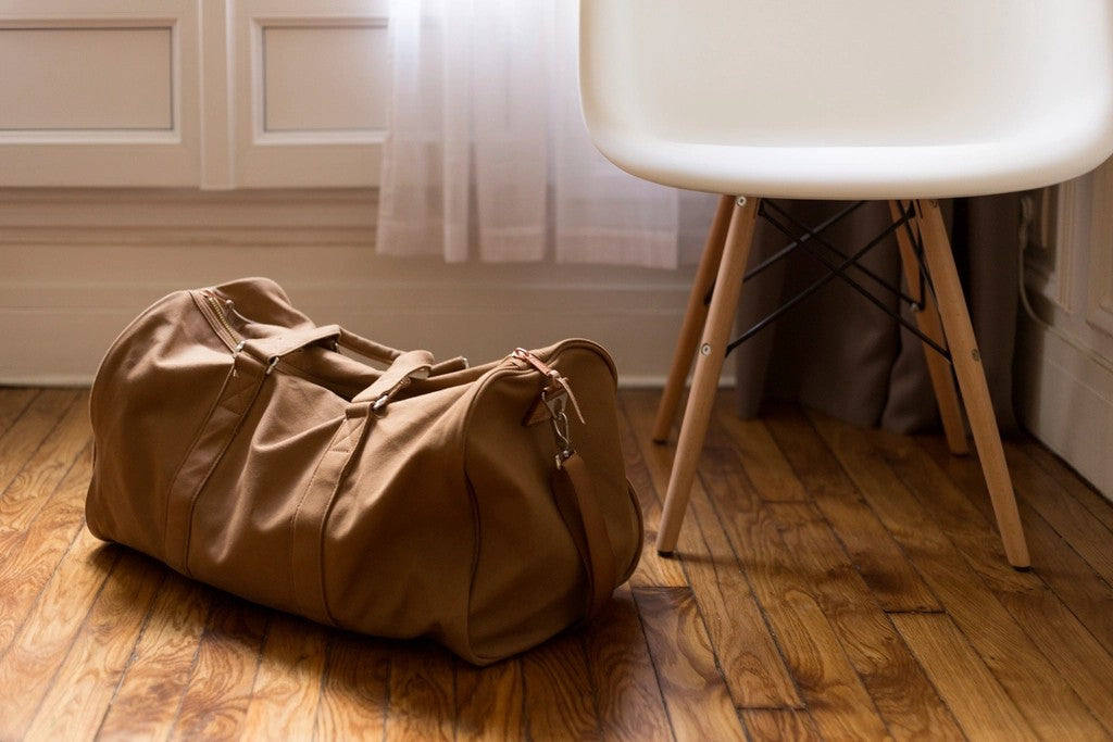 Small duffel bag by a chair for packing a flexible travel day