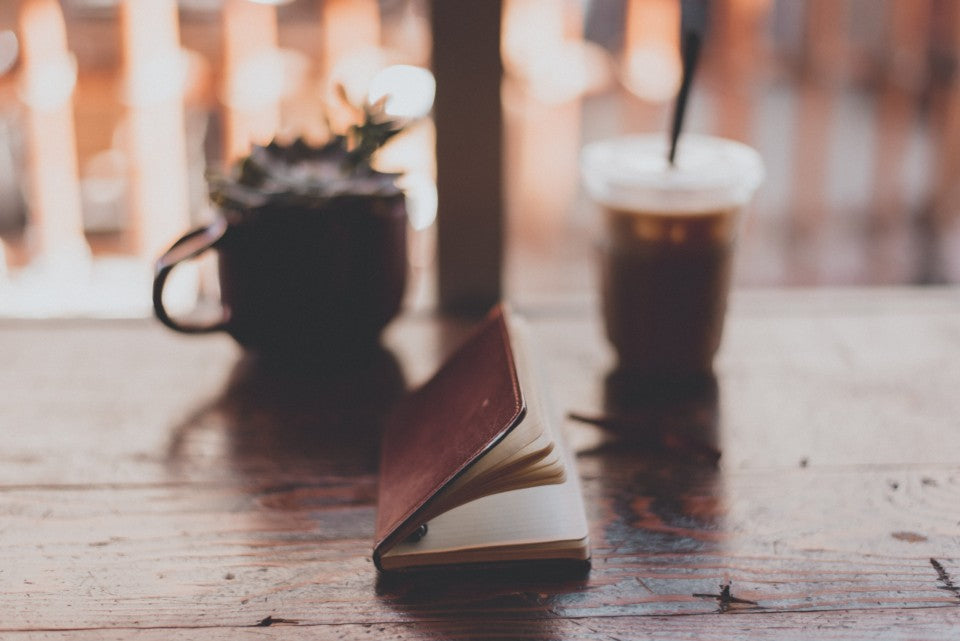 Open notebook and iced drink for noting simple food-boundary phrases