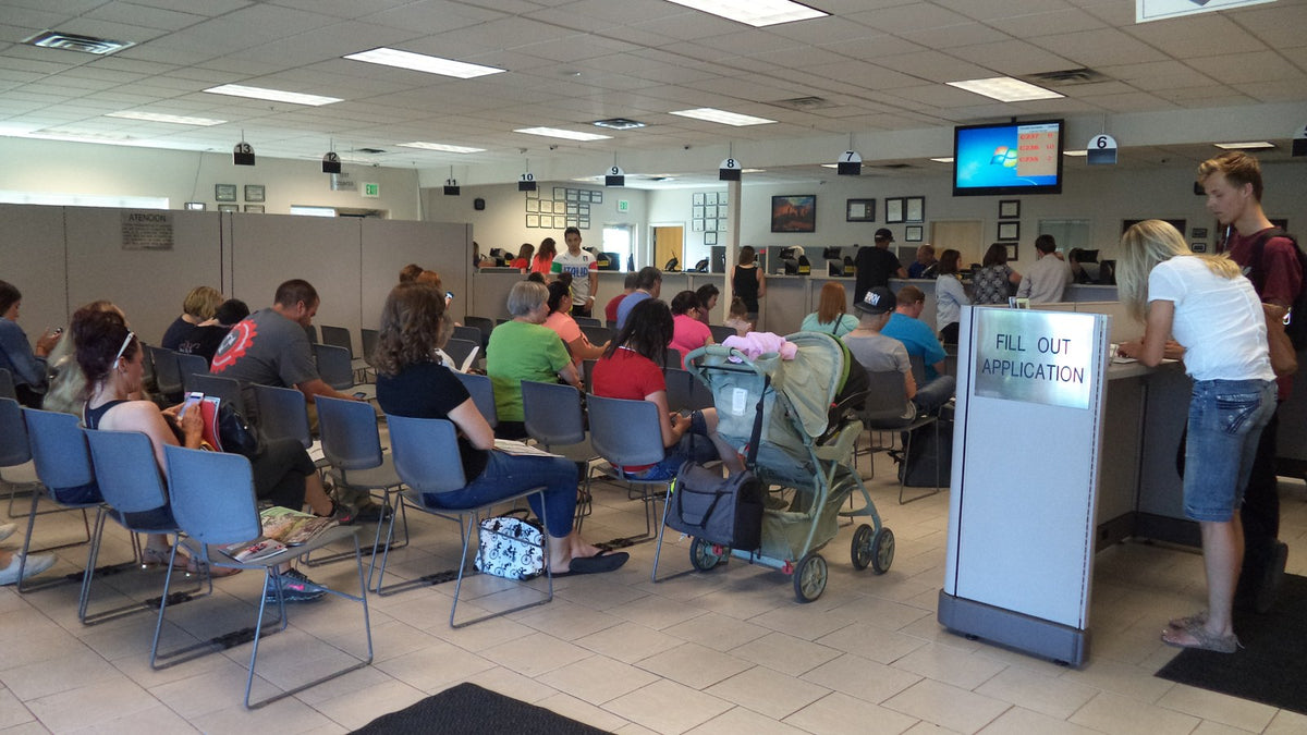 People waiting in a public service line, representing a flexible waiting plan for outings with IBD