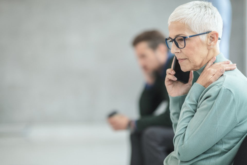 Seated older adult having a quiet phone call indoors