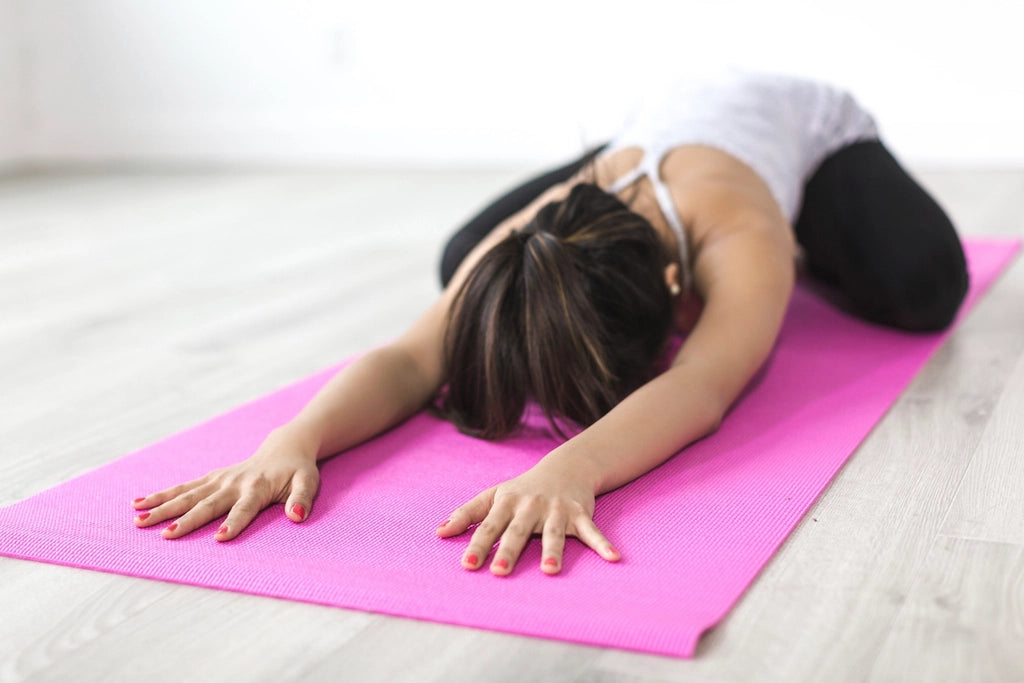 Person taking a gentle pause on a yoga mat during a calm home routine