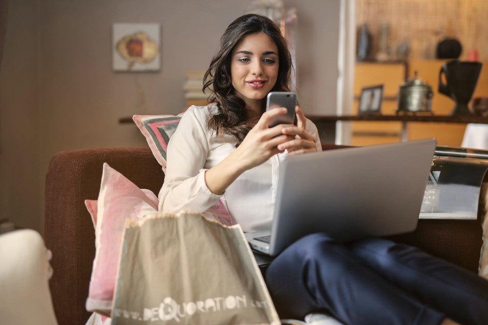 Person using a phone and laptop at home to plan a short pickup errand