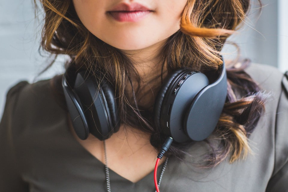Person with over-ear headphones in soft daylight for a quieter break