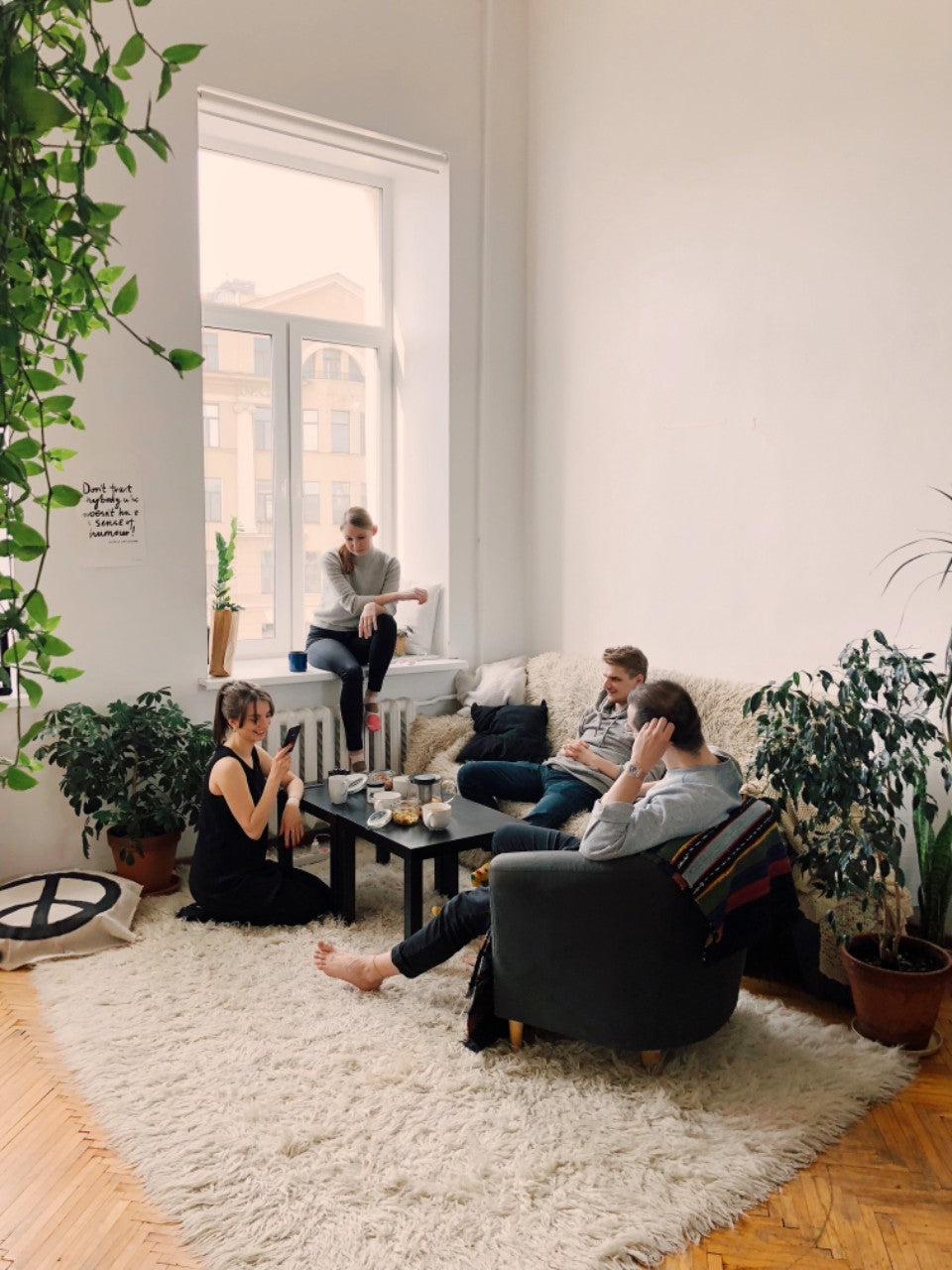 Four friends having a relaxed visit in a bright living room