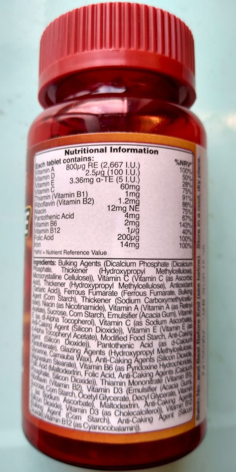 Back of an amber vitamin bottle showing a detailed nutritional information and ingredient label