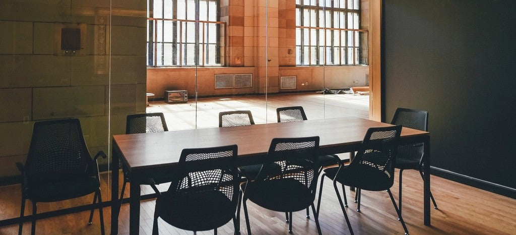 Warm, private meeting room with a wooden table and several chairs ready for a small group